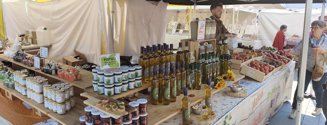 Marché en plein air avec huile, confitures, conserves et produits locaux divers exposés